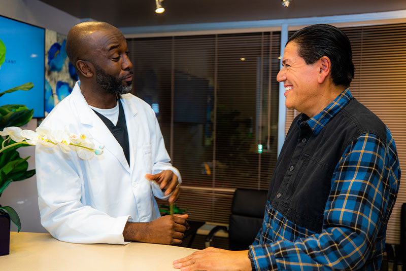 Patient and doctor talking at the front desk within the dental office